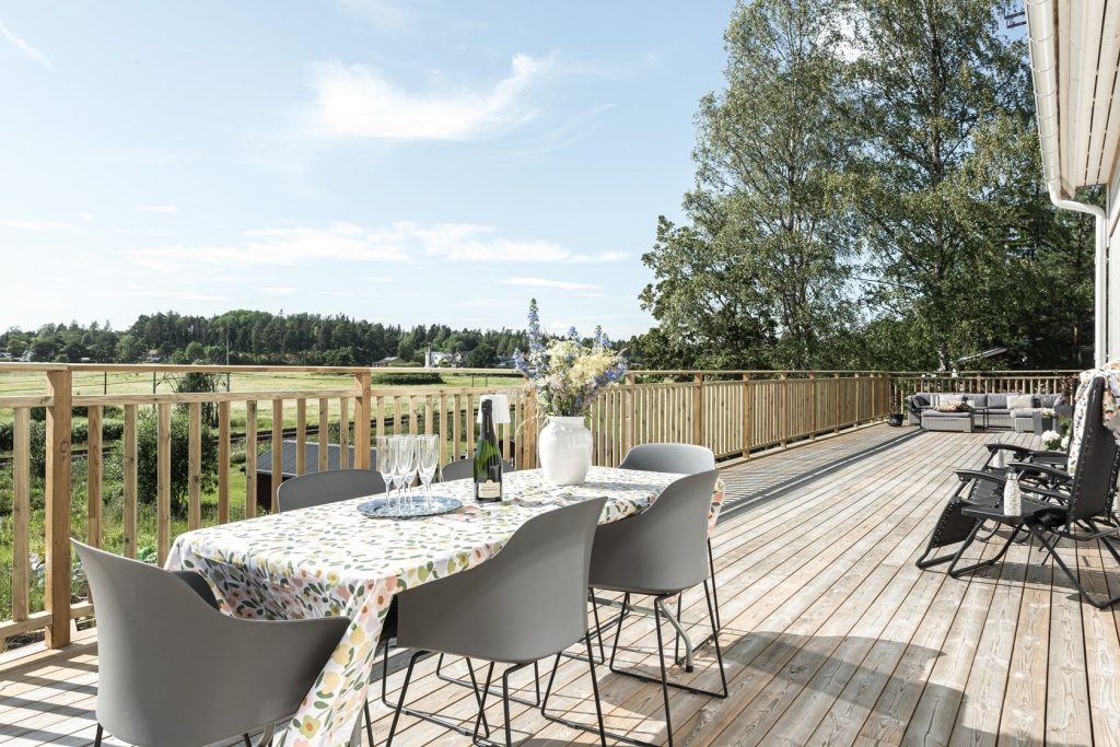 Stor altan med loungemöbler vid villa.