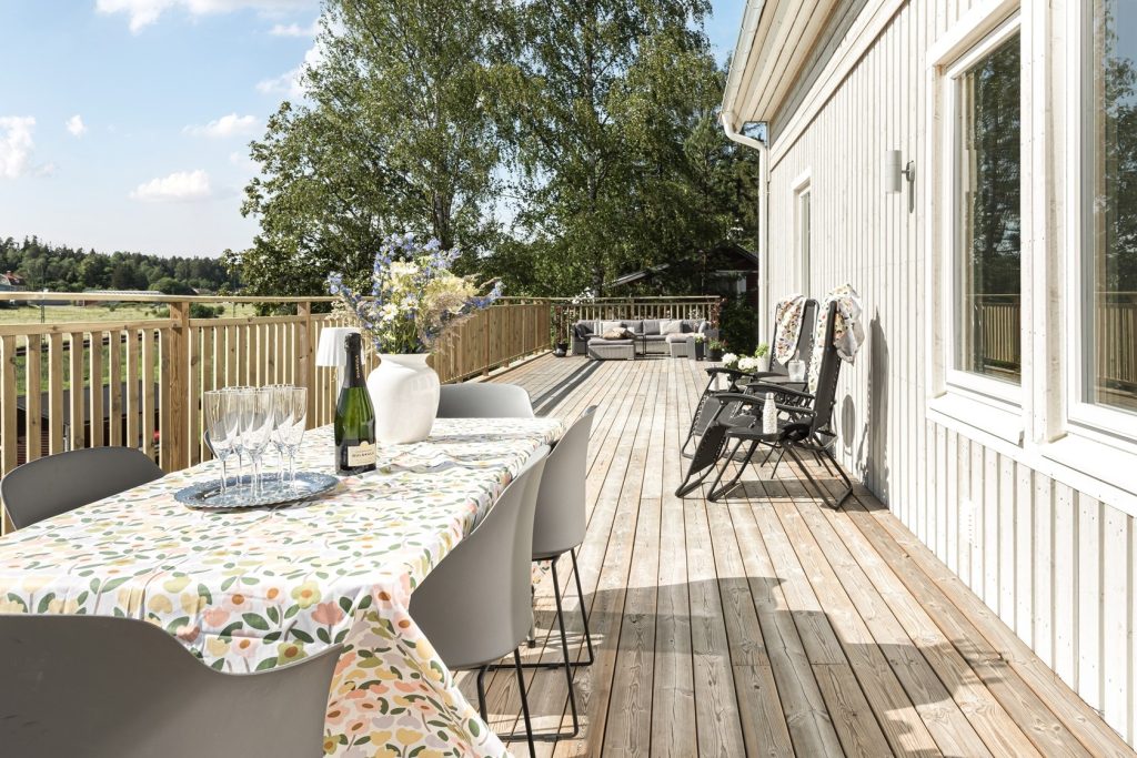 Altan med loungemöbler och stort trädäck